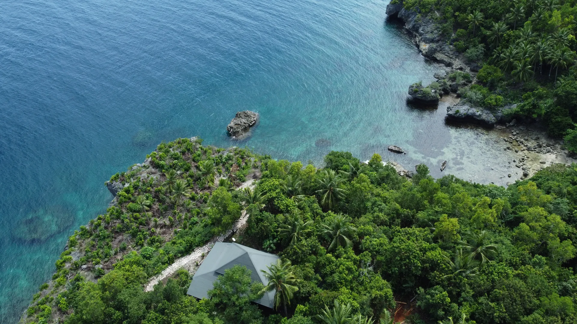 Coastal aerial showing the villas set between rainforest and reef water