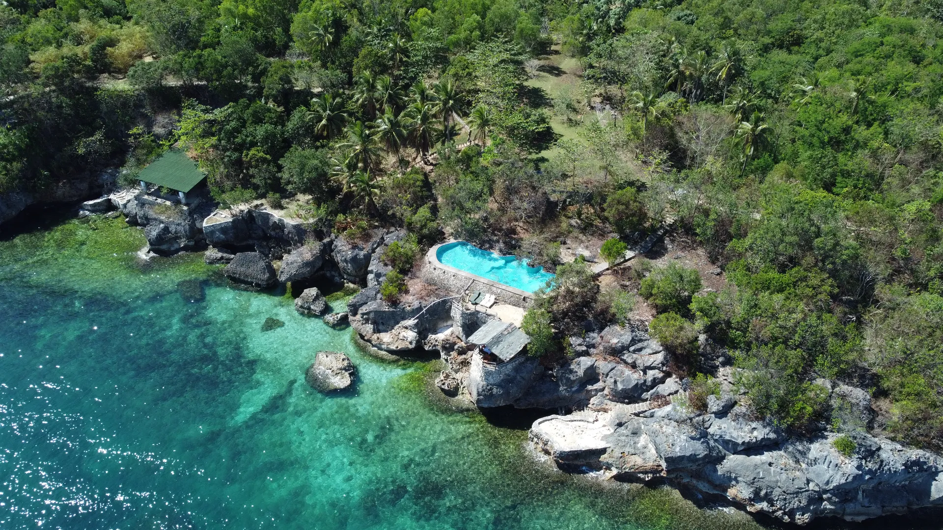Aerial view of the cliffside pool meeting turquoise water and limestone rocks